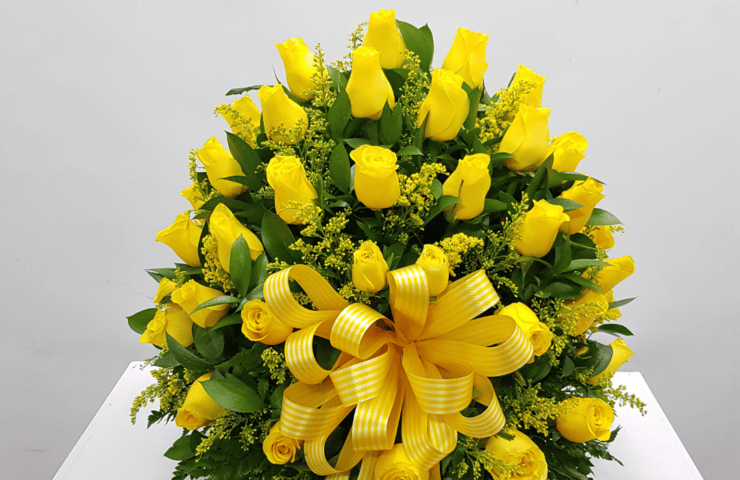 Regala un hermoso arreglo de rosas amarillas y moño decorativo. 