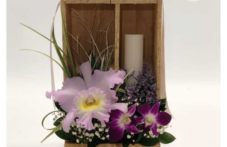 ramo funebre de orquideas y cirio.