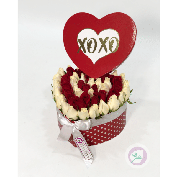 Caja en forma de corazón con rosas blancas y rojas.