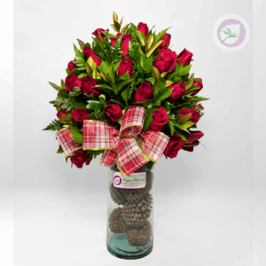 Corazón Navideño de Floristería Hojas Blancas combina la belleza clásica de las rosas rojas con el encanto cálido de la Navidad. Cada arreglo es elaborado con flores frescas, acompañado de follajes verdes, toques dorados y detalles decorativos como piñas de pino, moño navideño y elementos naturales que realzan su apariencia festiva. Todo el diseño se presenta en un florero de lujo, creando una pieza elegante, moderna y exclusiva perfecta para resaltar en cualquier espacio.