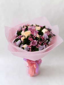 Delicado bouquet Encanto Pastel elaborado con rosas frescas, rusco, gypsophila y estatis, ideal para sorprender con un detalle elegante, romántico y lleno de color en cualquier ocasión especial.