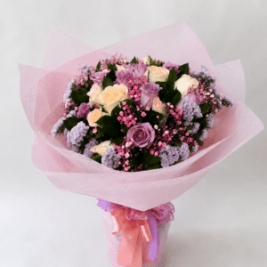 Delicado bouquet Encanto Pastel elaborado con rosas frescas, rusco, gypsophila y estatis, ideal para sorprender con un detalle elegante, romántico y lleno de color en cualquier ocasión especial.