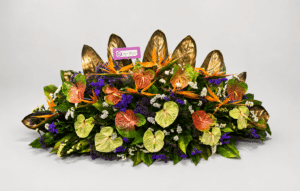 Una elegante jardinera elaborada con anturios, aves del paraíso, rusco, hojas de ave del paraíso y estatis. Un diseño exótico ideal para decorar espacios o sorprender con un regalo sofisticado.