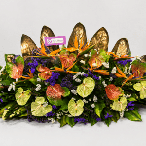 Una elegante jardinera elaborada con anturios, aves del paraíso, rusco, hojas de ave del paraíso y estatis. Un diseño exótico ideal para decorar espacios o sorprender con un regalo sofisticado.