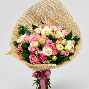 Elegante bouquet Romance elaborado con rosas, rosa spray y rusco, decorado con delicadas perlas y presentado en una envoltura de fique con moño. Un detalle romántico, natural y sofisticado para sorprender.