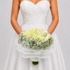 Elegante yugo floral elaborado con rosas y delicada gypsophila, acompañado de una sofisticada entretela perlada que aporta textura y luminosidad. Un diseño romántico para realzar la decoración de tu boda.