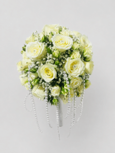 Yugo perla de amor, elegante yugo floral redondo elaborado con rosas, rosas spray y gypsophila, acompañado de delicados lazos de perlas. Un diseño romántico y sofisticado para realzar la decoración de tu boda.