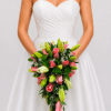 El Yugo Nupcial Encanto de Lirios combina lirios, rosas y gypsophila en una composición floral delicada y elegante, ideal para realzar la decoración de ceremonias de matrimonio.
