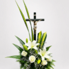 Homenaje de luz es un elegante arreglo fúnebre elaborado con lirios, rosas, gypsophila, caspia y follajes naturales, acompañado de un detalle de Cristo. Una composición sobria y delicada para expresar respeto, amor y condolencias.