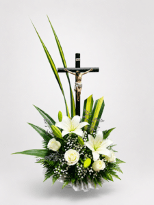 Homenaje de luz es un elegante arreglo fúnebre elaborado con lirios, rosas, gypsophila, caspia y follajes naturales, acompañado de un detalle de Cristo. Una composición sobria y delicada para expresar respeto, amor y condolencias.