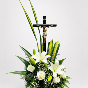 Homenaje de luz es un elegante arreglo fúnebre elaborado con lirios, rosas, gypsophila, caspia y follajes naturales, acompañado de un detalle de Cristo. Una composición sobria y delicada para expresar respeto, amor y condolencias.