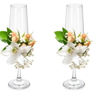 Delicada decoración floral para copas nupciales, elaborada con orquídeas, rosa spray, rusco y gypsophila. Una composición elegante y romántica para acompañar uno de los momentos más especiales de la celebración.